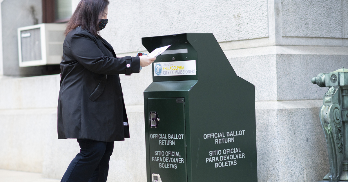 A voter casts her early voting ballot at drop box outside of City Hall on October 17, 2020 in Philadelphia, Pennsylvania.