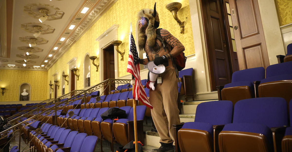 WASHINGTON, DC - JANUARY 06: A protester screams "Freedom" inside the Senate chamber after the U.S. Capitol was breached by a mob during a joint session of Congress on January 06, 2021 in Washington, DC. Congress held a joint session today to ratify President-elect Joe Biden's 306-232 Electoral College win over President Donald Trump. A group of Republican senators said they would reject the Electoral College votes of several states unless Congress appointed a commission to audit the election results. Pro-Trump protesters entered the U.S. Capitol building during demonstrations in the nation's capital. 
