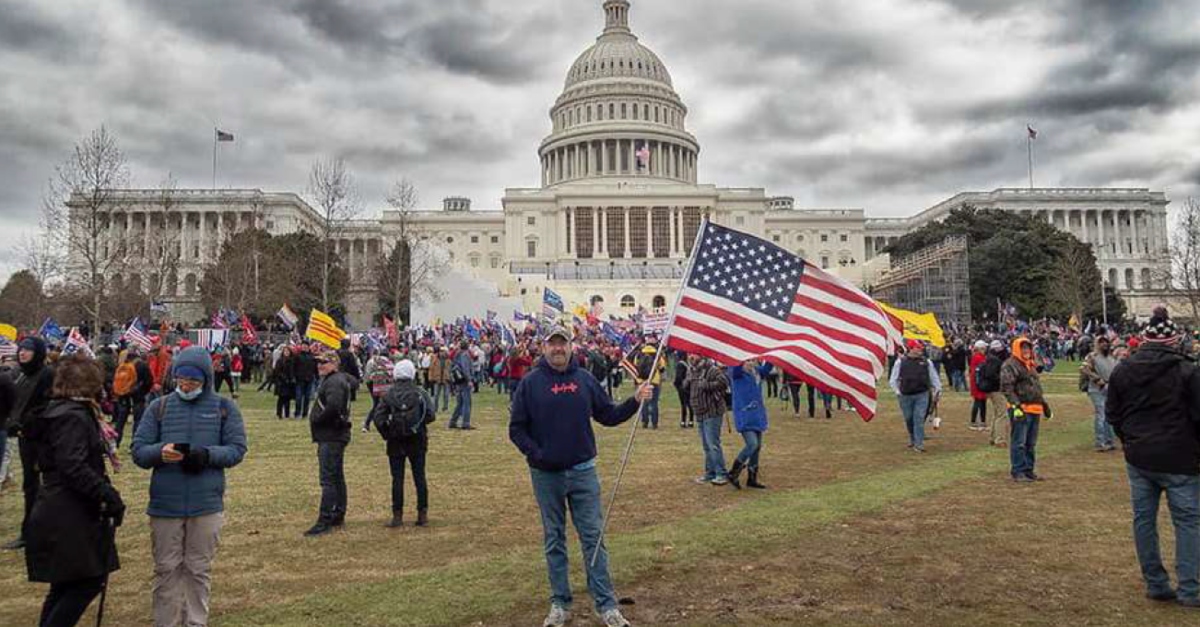 Man identified as Christopher M. Kelly, with U.S. flag.