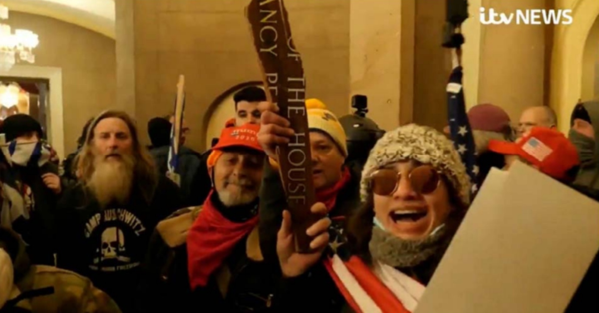 William Merry, with a red bandana around his neck; Paul Westover, in the white hat; and Emily Hernandez, in the sunglasses; pictured inside the Capitol on Jan. 6 with a stolen shard of Nancy Pelosi's name plate.