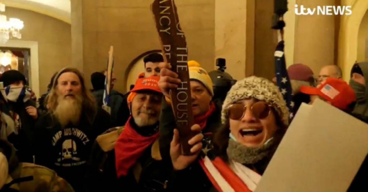 Woman identified as Emily Hernandez holds Nancy Pelosi's name plate