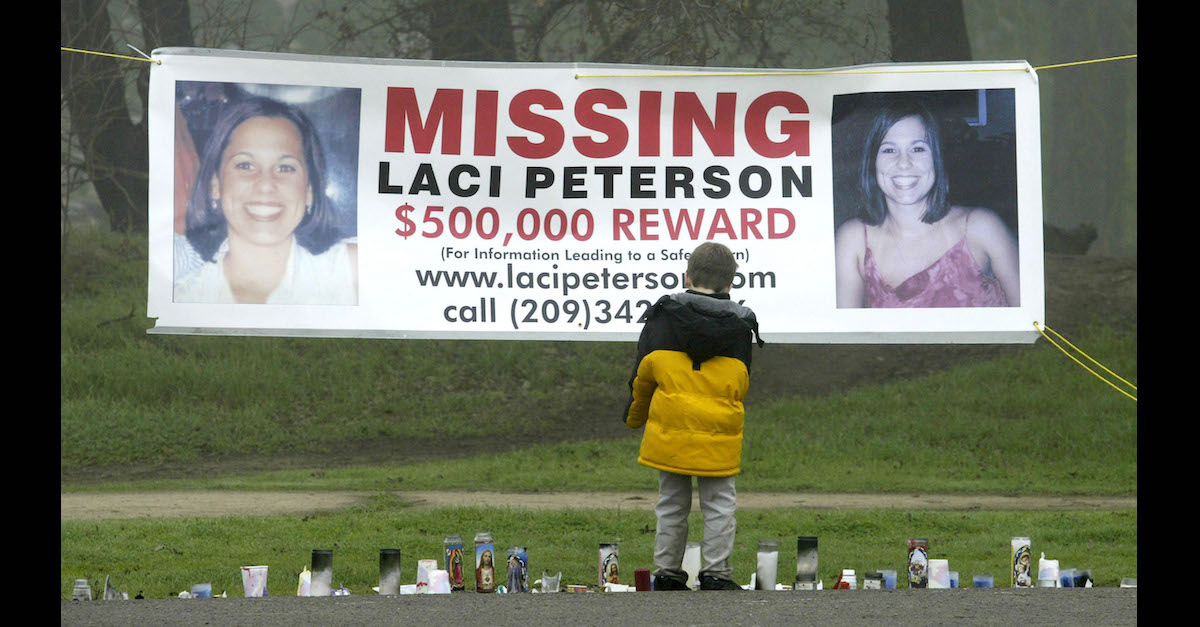 A young child stops to look at a makeshift memorial and a missing person's banner offering a half-million dollar reward for the safe return of Laci Peterson. The banner was in the East La Loma Park on January 4, 2003 in Modesto, California. Laci's body wasn't discovered until mid-April 2003. (Photo by Justin Sullivan/Getty Images.)