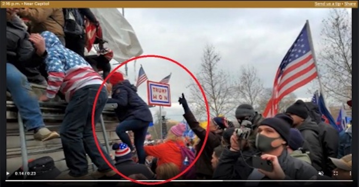 Jean Lavin and Carla Krzywicki climb a bike rack-turned-ladder in order to reach the Capitol.