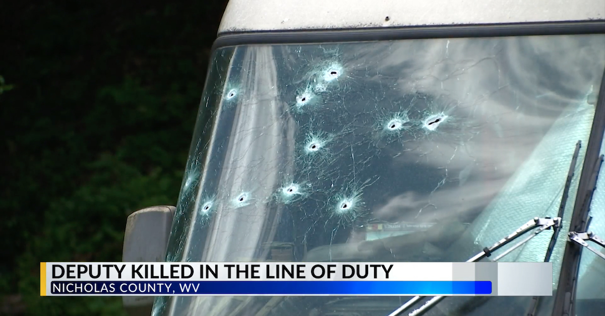 A camper in Birch River, W. Va., contained more than two dozen bullet holes after a shootout left one sheriff's deputy and one suspect dead.  (Screengrab via WTRF-TV.)