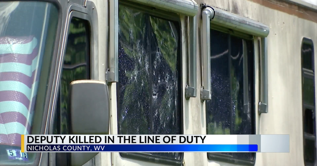 A camper in Birch River, W. Va., contained more than two dozen bullet holes after a shootout left one sheriff's deputy and one suspect dead.  (Screengrab via WTRF-TV.)