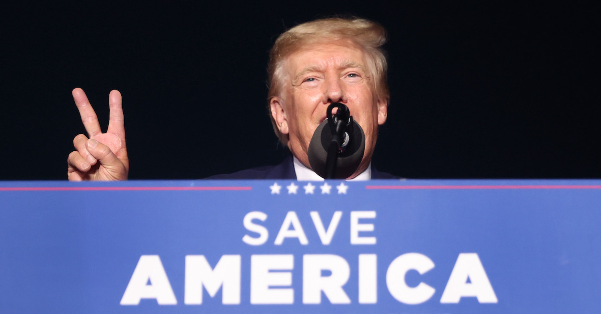 Donald Trump speaks above a "Save America" sign attached to a podium.