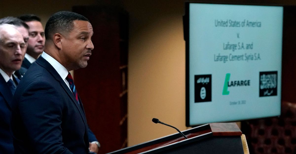 Eastern District of New York US Attorney Breon Peace, seen in profile wearing a dark suit and tie in front of a display that says "United States of America v. Lafarge SA and Lafarge Cement Syria SA" announces a guilty plea by French cemet giant Lafarge on Oct. 18, 2022.