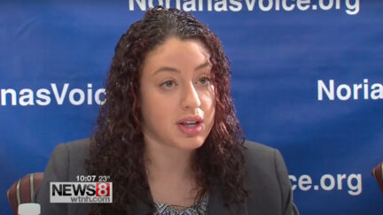 A photo shows Noriana Radwan speaking at a press conference.