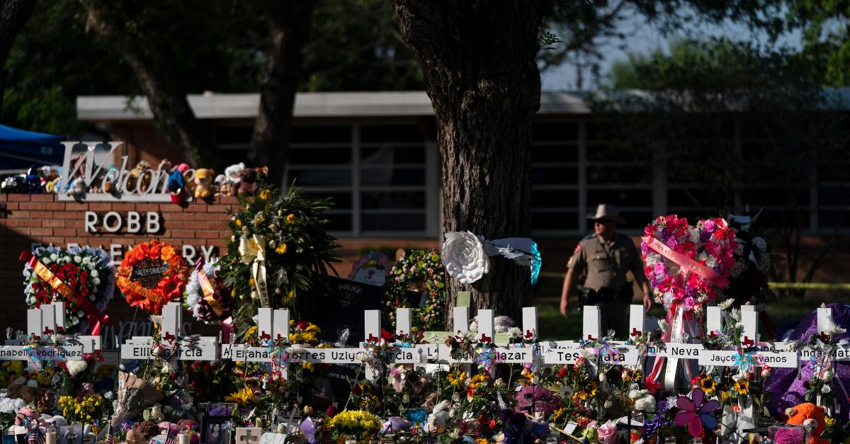 Flowers and candles are placed around crosses on May 28, 2022, at a memorial outside Robb Elementary School in Uvalde, Texas, to honor the victims killed in the school shooting. The teenage cousin of the gunman responsible for deadly school shooting in Uvalde, Texas, has been arrested Monday, Aug. 7, 2023, after his family told police he was trying to buy a gun and “do the same thing,” court records show. (AP Photo/Jae C. Hong, File)