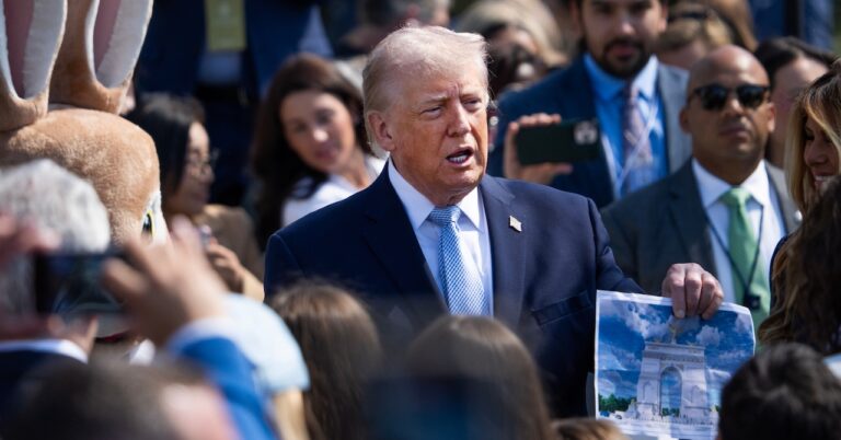 President Donald Trump holds a picture of the proposed Triumphal Arch.