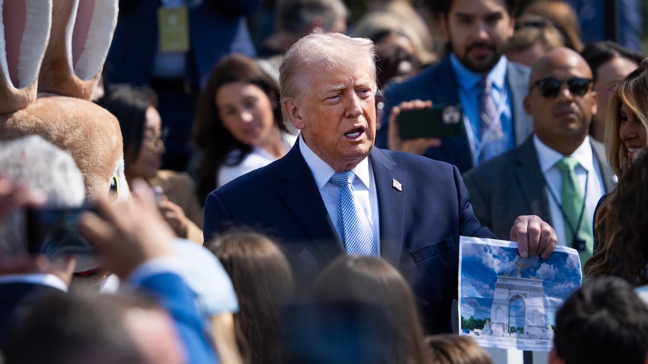 President Donald Trump holds a picture of the proposed Triumphal Arch.